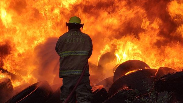 Personal de Bomberos de Tepeji trabaja para sofocar un incendio de llantas en un predio que se ubica frente a la empresa Zaga.